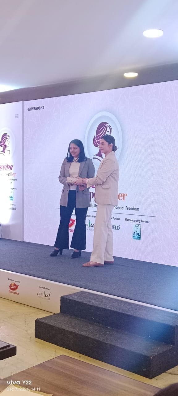 Dr. Shweta Goyal receiving recognition on stage at Grihshobha EmpowerHer 2024
